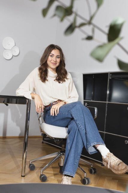 Smiling COX Coaching & Consulting employee in a modern office